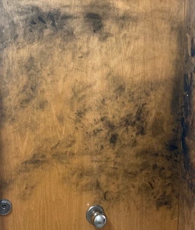 Imagen secundaria 2 - Arriba, el piso donde residía la víctima, el 4º 2ª del 200 de Consell de Cent, precintado por los Mossos. Sobre estas líneas, pisadas en la escalera de la entrada con restos de sangre, y una huella parcial en la puerta de los bajos del edificio, donde reside la vecina que encontró el cadáver y alertó a Emergencias