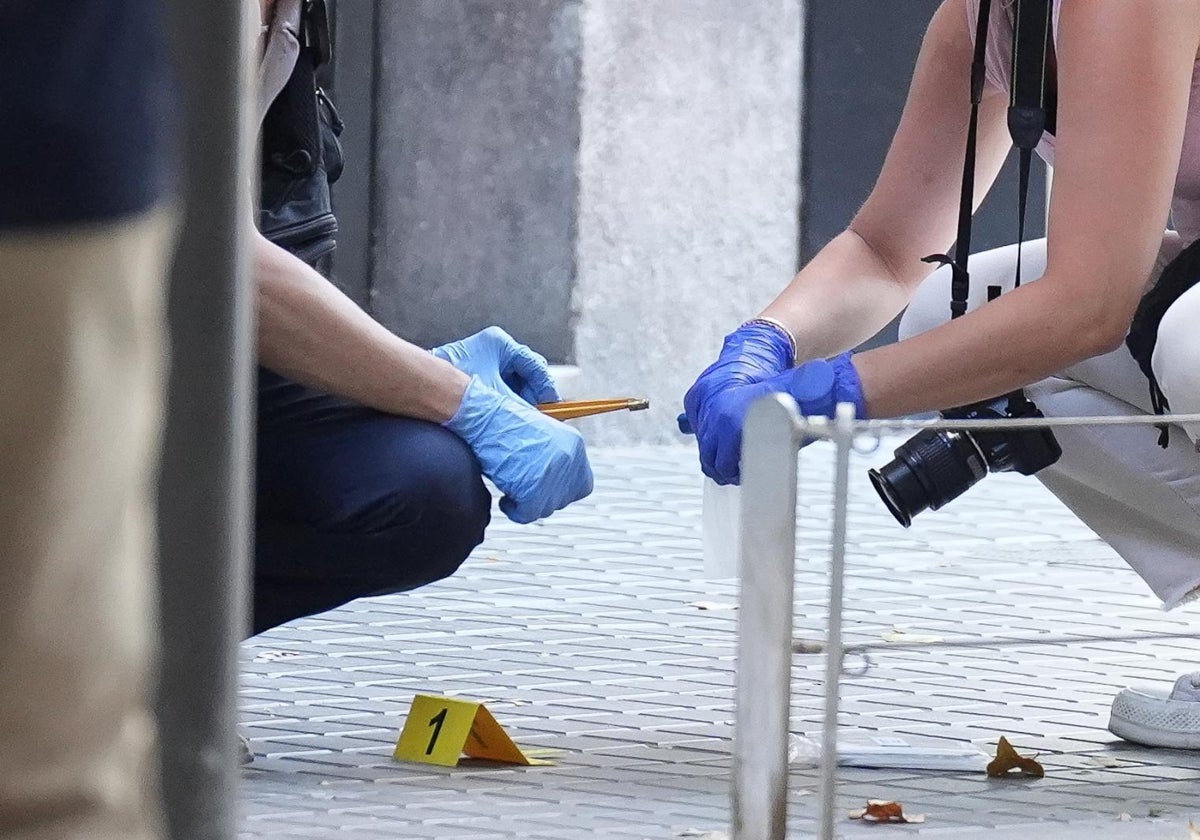 Dos agentes de la Científica de los Mossos recogen un casquillo tras la ejecución en el centro de Barcelona, el pasado martes