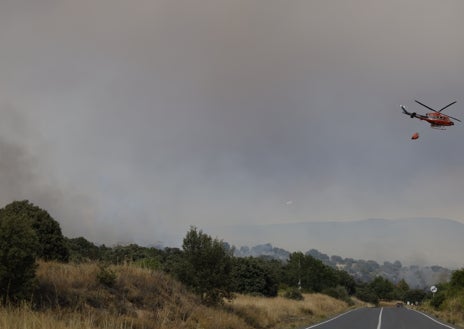 Imagen secundaria 1 - Arriba, zona quemada; sobre estas líneas, labores de extinción y el alcalde de Navaluenga