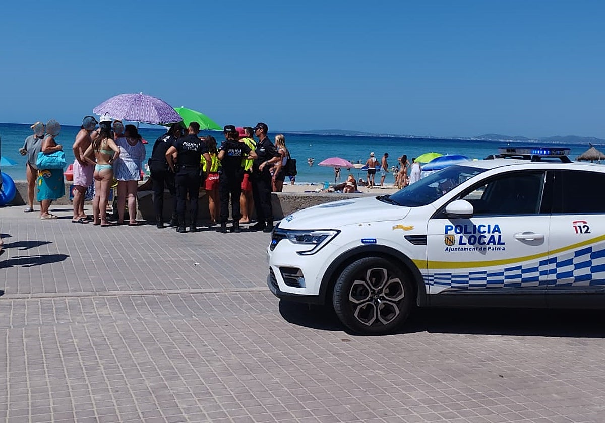 Agentes de la policía atienden a la bañista en la Playa de Palma.