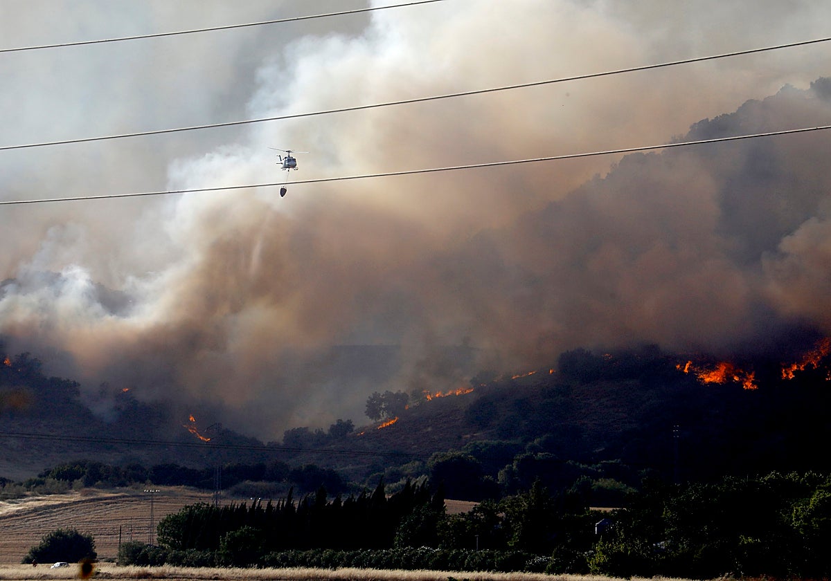 Un helicóptero evacúa aguaen la zona del incendio en la sierra de Córdoba