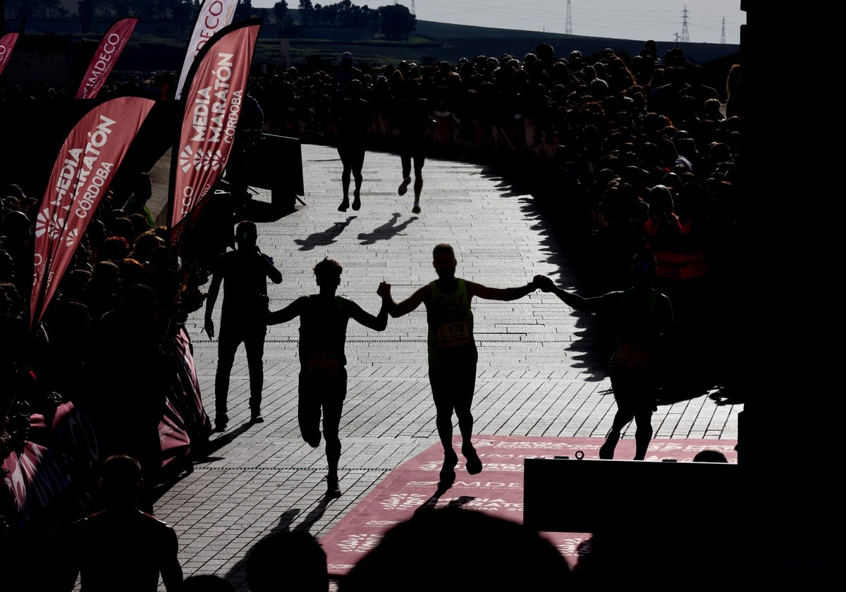 Varios corredores entran en la meta en la última Media Maratón de Córdoba