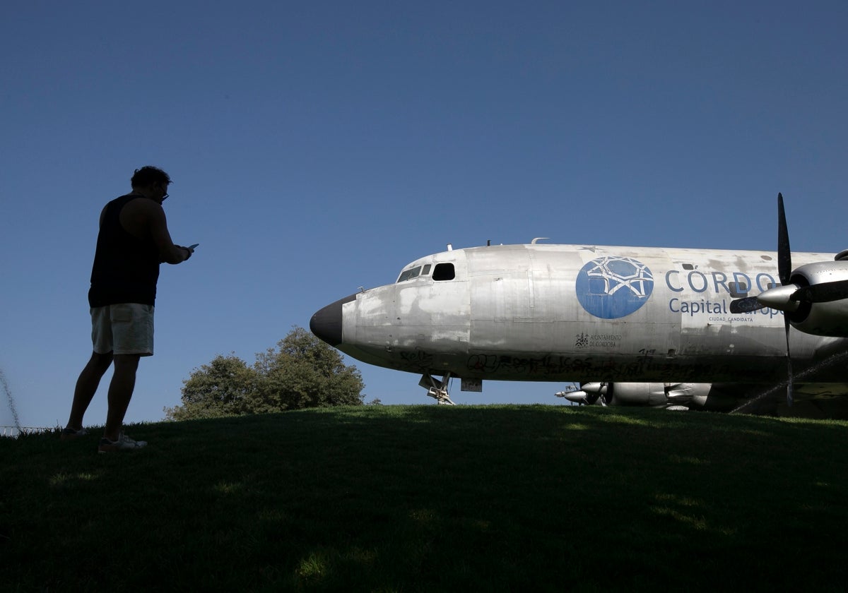 Una persona fotografía el avión cultural en la loma del Balcón del Guadalquivir