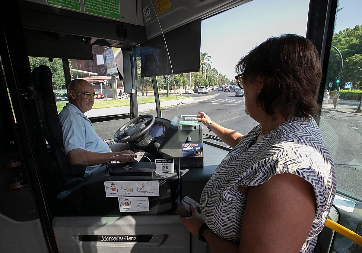 Una mujer paga en metálico en un autobús de Aucorsa