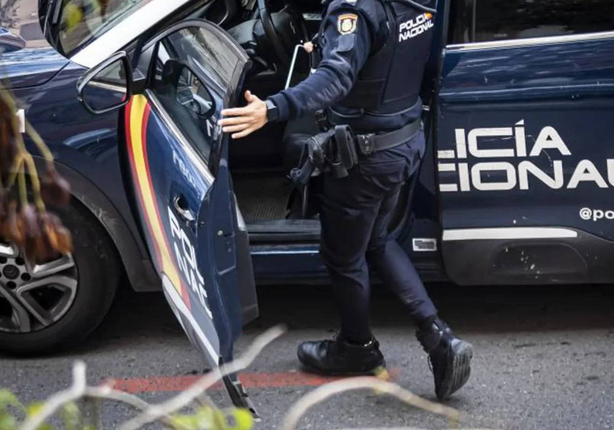 Un agente de la policía nacional subiendo a un vehículo