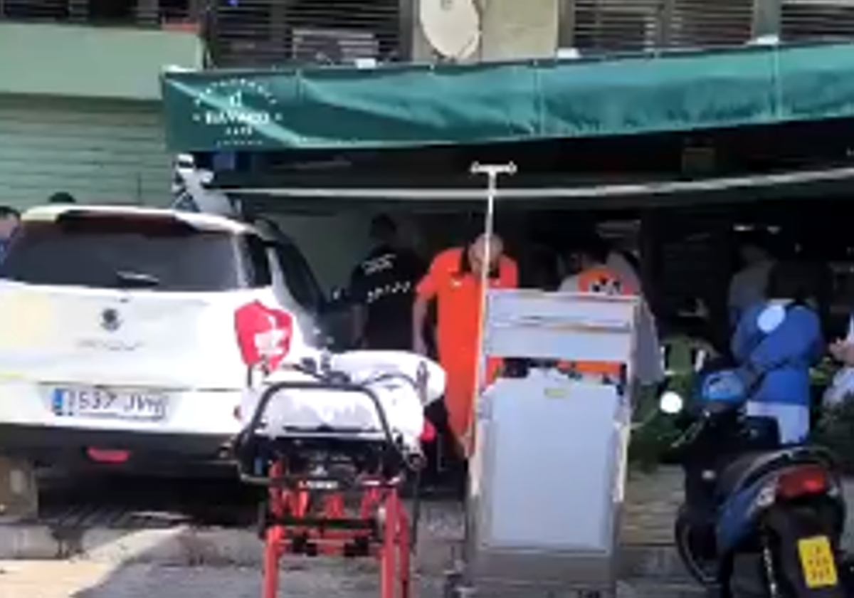 El coche estrellado contra la terraza del establecimiento, mientras los servicios sanitarios atienden a los heridos