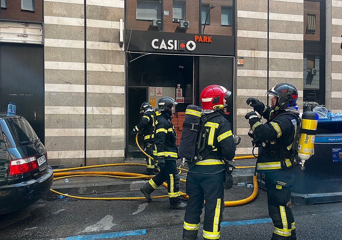 Los Bomberos del Ayuntamiento de Madrid durante los trabajos de extinción del incendio en una casa de apuestas de Ciudad Lineal, este domingo