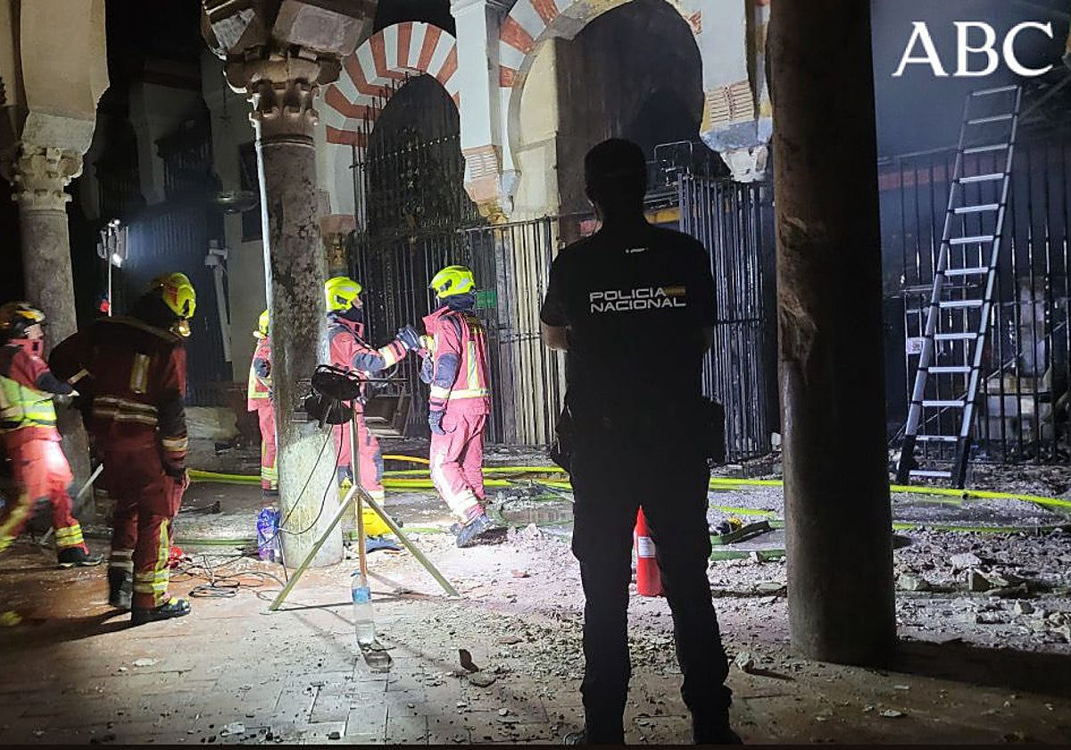 Bomberos en el interior de la Mezquita junto a la capilla incendiada
