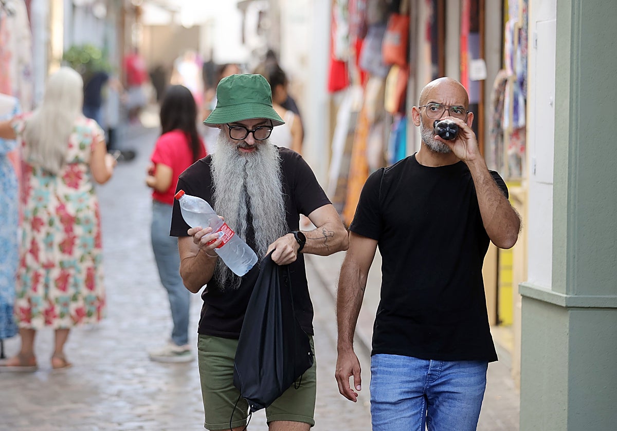 Dos turistas se hidratan durante un paseo por las calles de Córdoba
