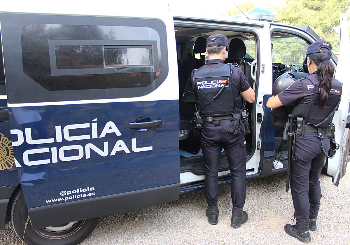 Imagen de dos agentes de Policía Nacional junto al furgón en Valencia