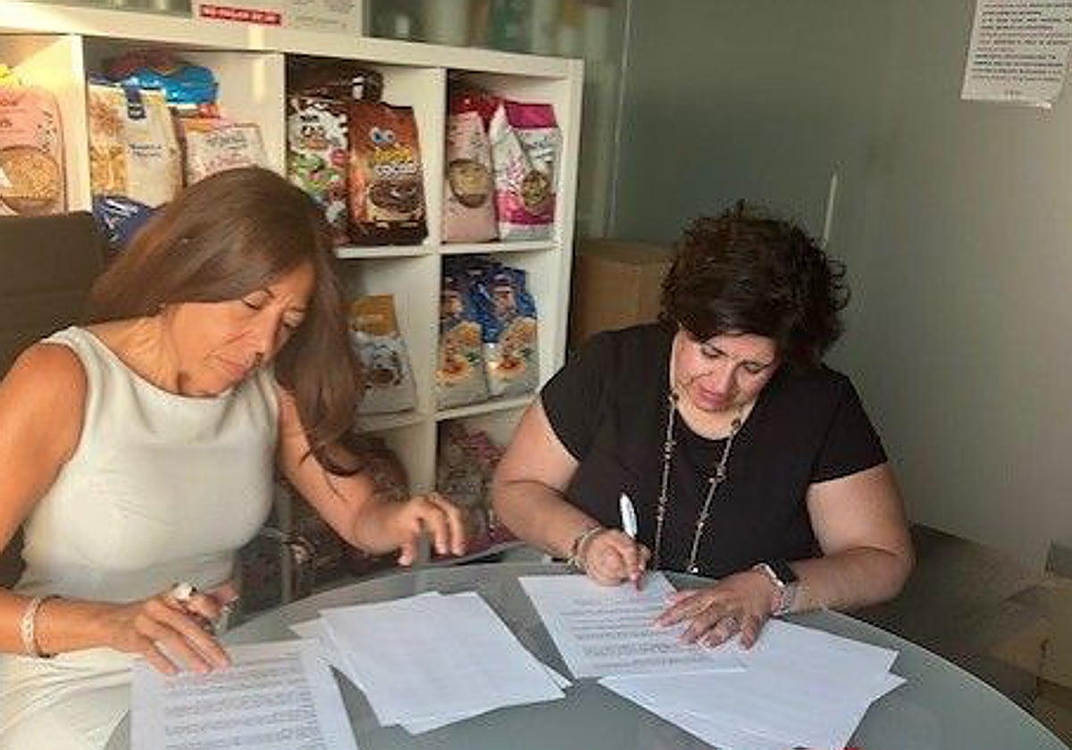 La responsable de Ventas y Exportación de Haricaman firmando el convenio con la secretaria general de Cáritas Mónica