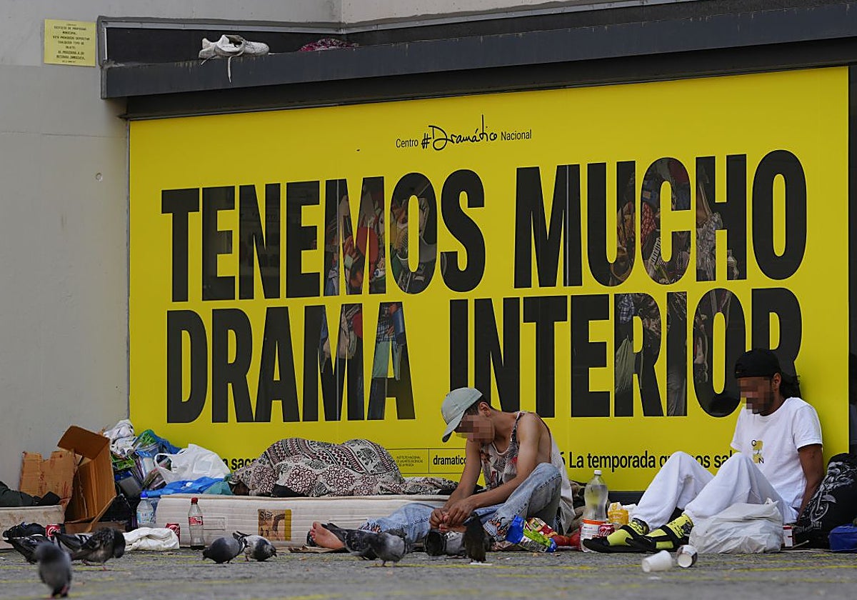 Tres personas sin hogar descansan a la sombra del Teatro Valle-Inclán, este viernes