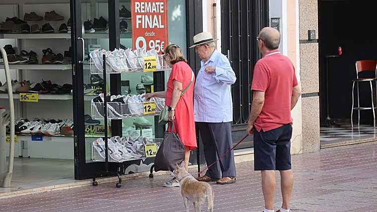 Dos personas observan una tienda de calzado en la avenida de la Viñuela
