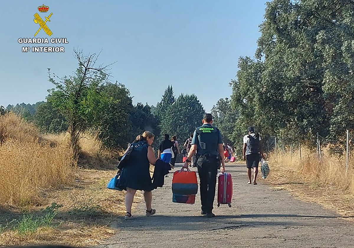 Un agente de la Guardia Civil acarrea el equipaje de una viajera