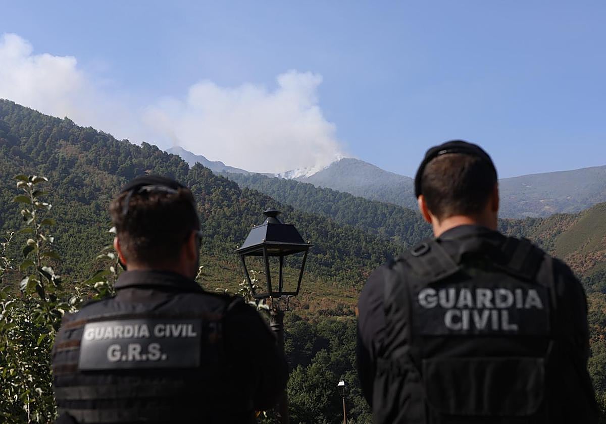 Dos agentes de la Guardia Civil observan el incendio de Degaña, también en Asturias