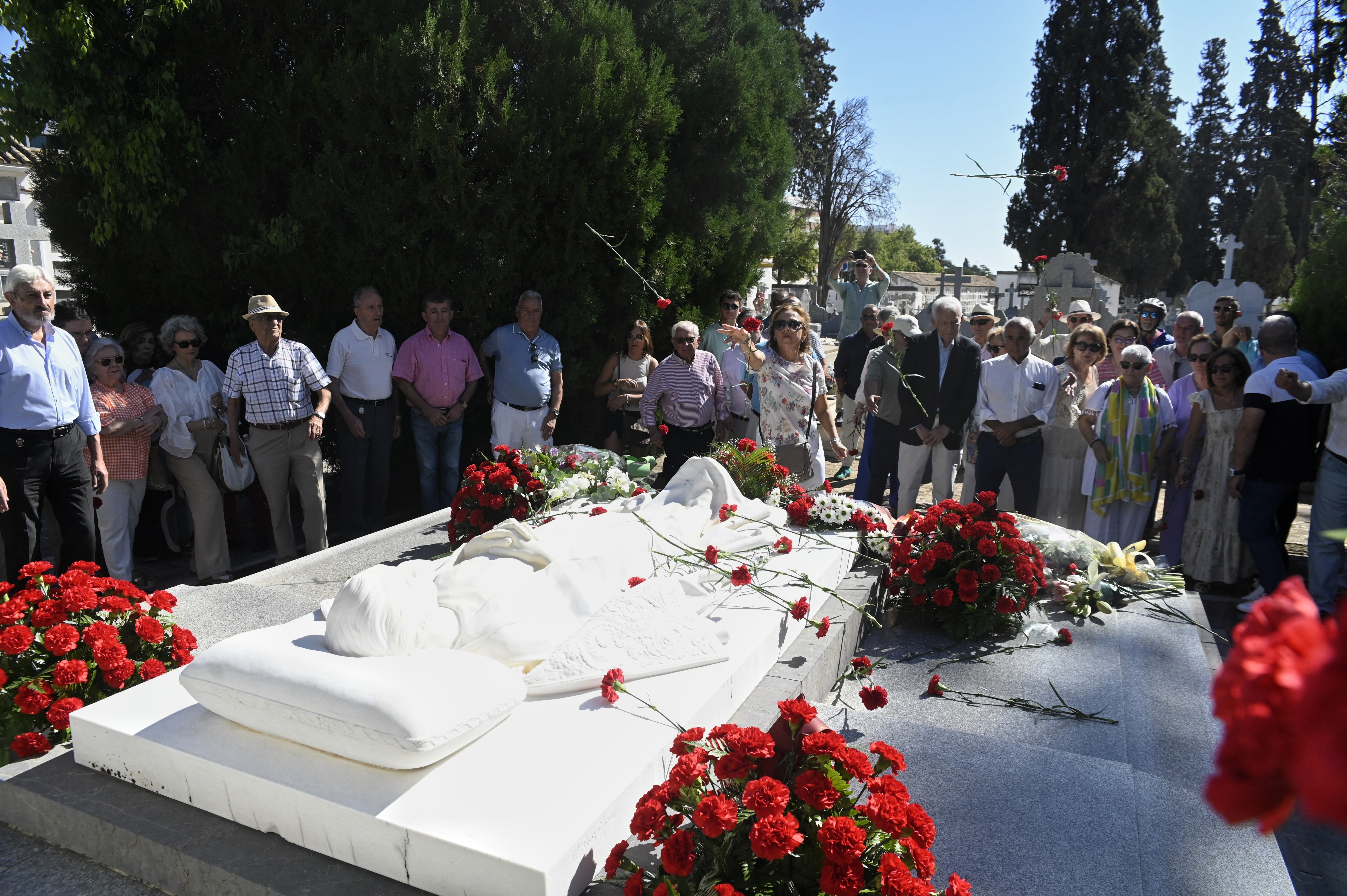 Los asistentes al homenaje a Manolete lanzan, como es tradicional, flores sobre el mausoleo del diestro