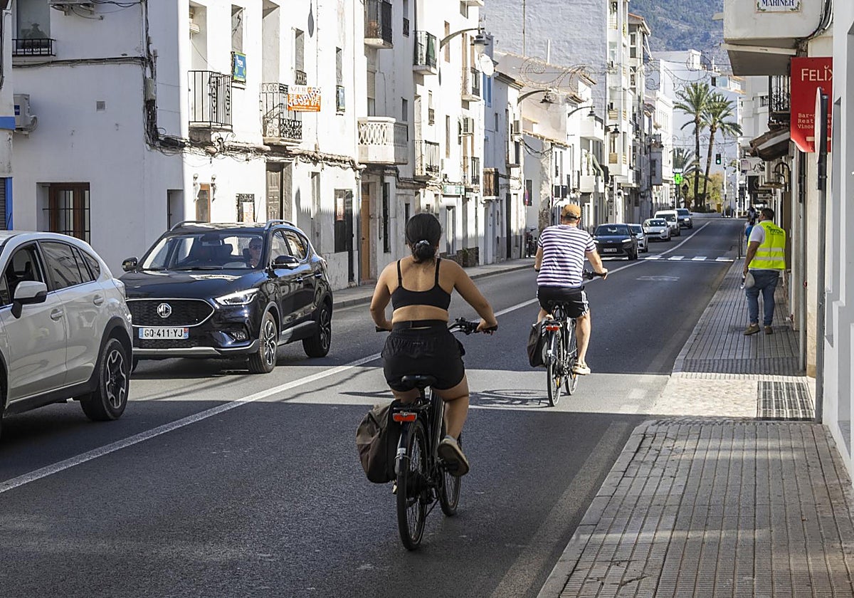 Ciclistas y transeúntes transitan por una calle de Altea (Alicante)