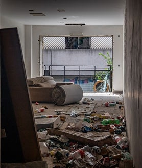 Imagen secundaria 2 - Uno de los pasillos, desprovistos de toda luz, que da acceso a los pisos okupados; en las fotos pequeñas, los grafitis se acumulan en el interior del bloque, y los destrozos y la basura acumulada inundan todas las estancias