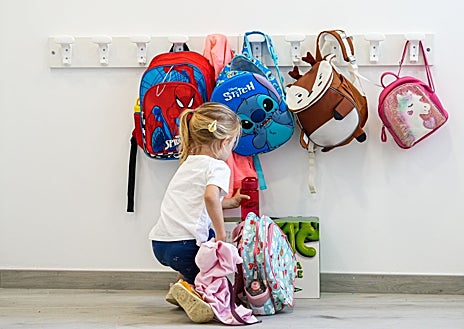 Imagen secundaria 1 - Sobre estas líneas, dos de las familias de Cubillos que se empeñaron en la reapertura del colegio del municipio. Paula, una de las alumnas, coloca la mochila en el perchero y Felisa Gallego, mamá de Kilian, uno de los tres niños que acude al centro de Sanzoles