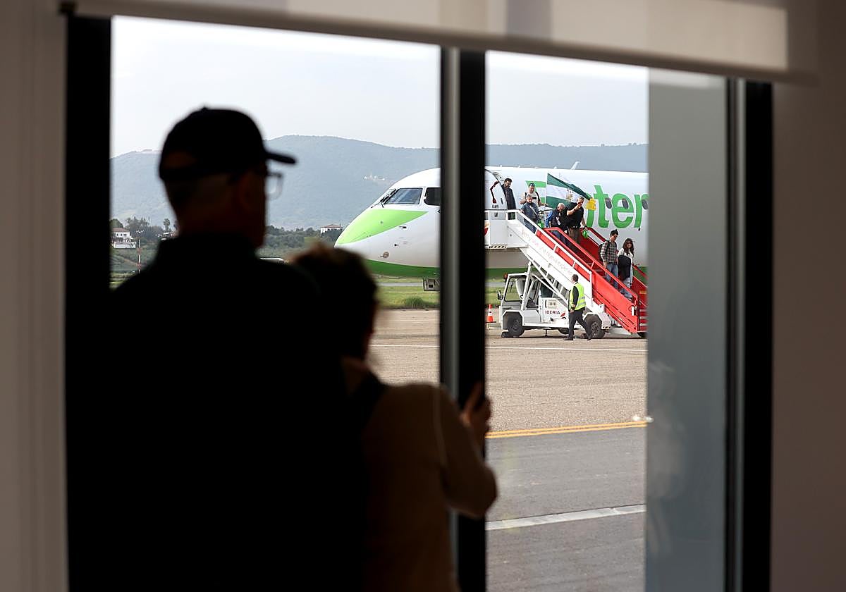 Un par de personas observan la llegada del primer vuelo de Binter a Córdoba