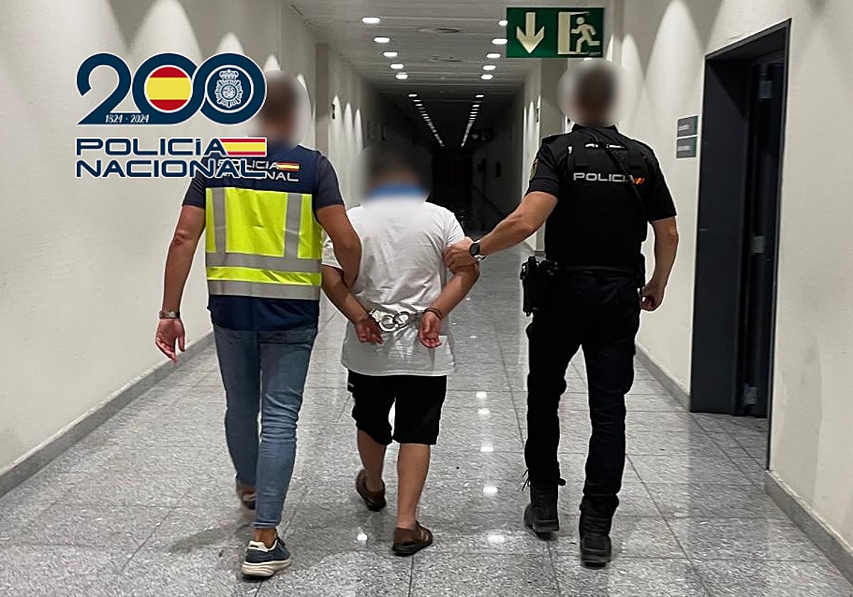 Imagen de dos agentes con el detenido