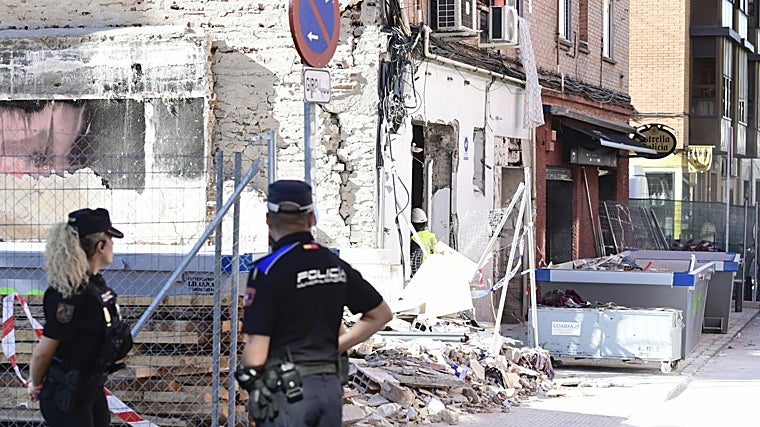 Agentes de la Policía Nacional y la Policía Municipal de Madrid junto al edificio en el que se produjo la detonación, este domingo
