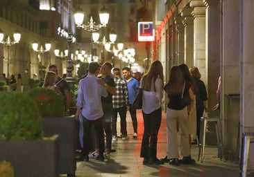 Jóvenes en la puerta de uno de los numerosos locales de ocio de la calle Ganivet