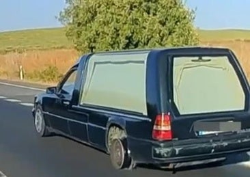 Imagen del coche fúnebre circulando sin rueda