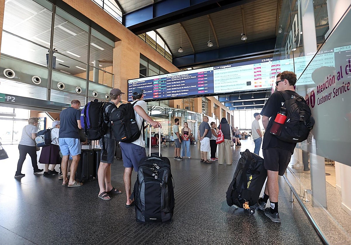 Viajeros consultando los retrasos de sus AVE en las pantallas de la estación Julio Anguita de Córdoba