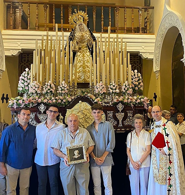 Antonio Muñoz, coin el reconocimiento de la cofradía en sus manos, ante el paso de la Nazarena sin palio