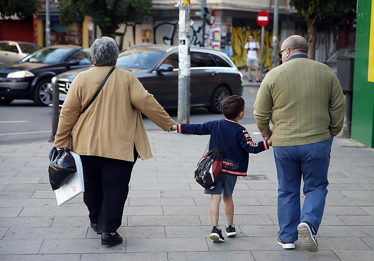 Una pareja de abuelos camina junto a su nieto