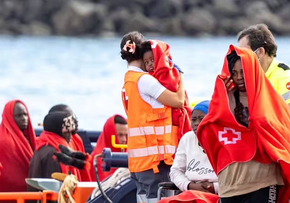 Agentes de los equipos de emergencia atienden a migrantes en el muelle de Arrecife