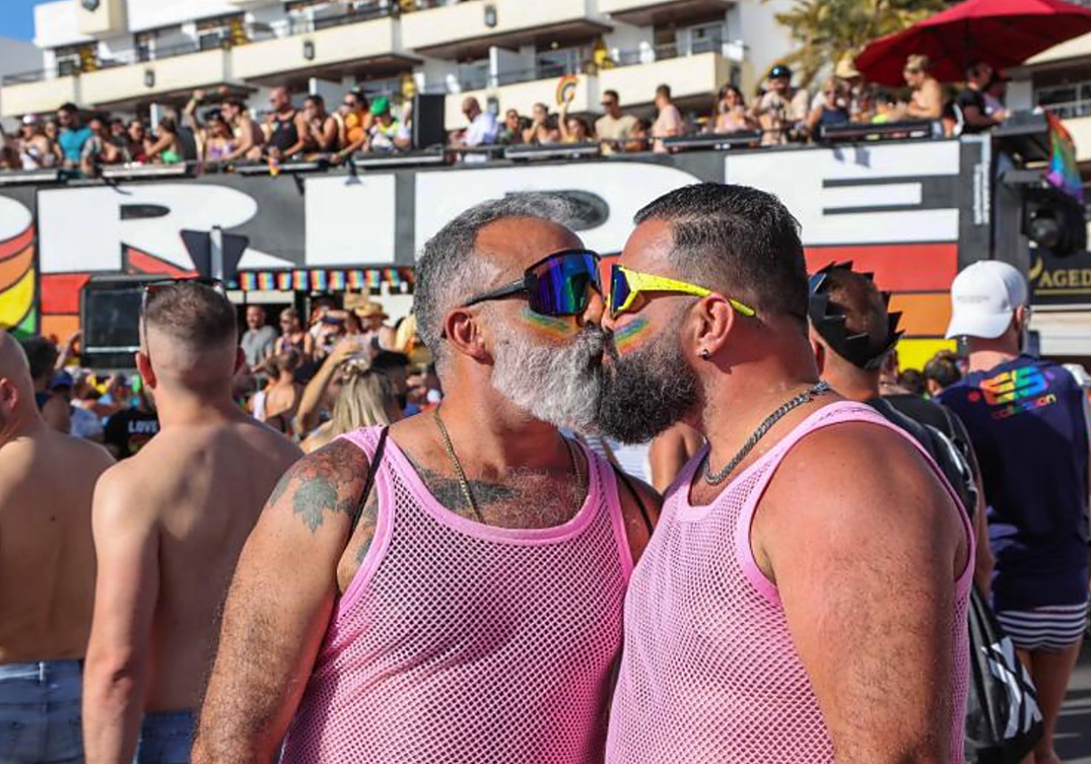 Una pareja se besa frente a una carroza en la fiesta del Maspalomas Pride by Freedom