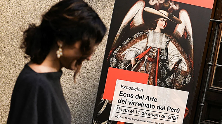 Díaz Ayuso, junto al cartel de la exposición, con uno de los ángeles arcabuceros