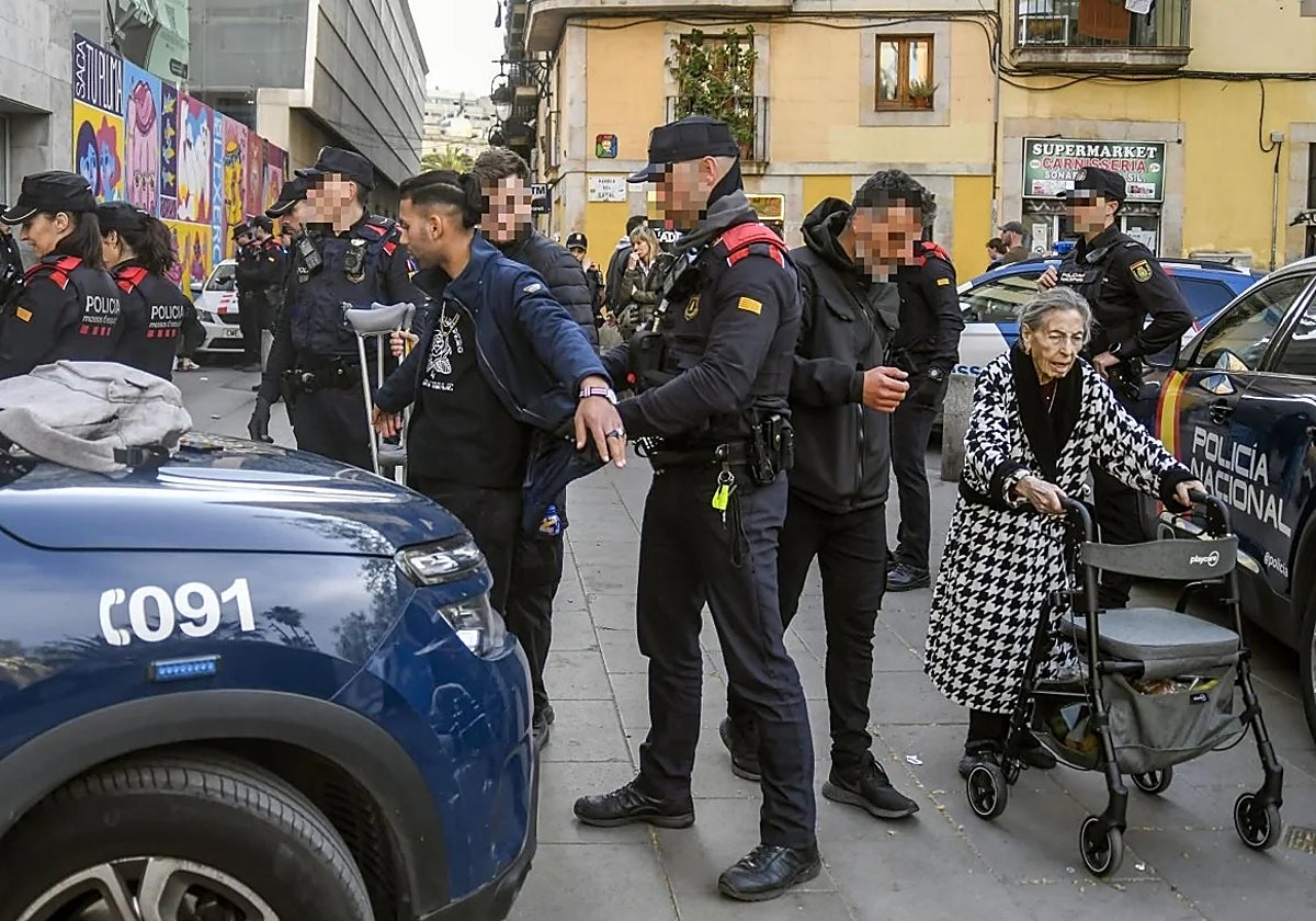 Agentes de los Mossos y la Policía Nacional durante el registro a varios multirreincidentes en el Raval.