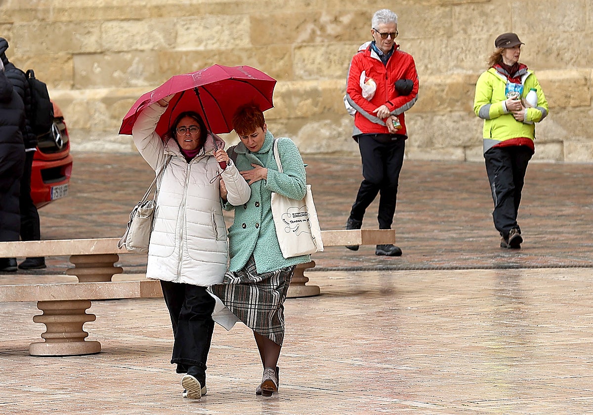 Una pareja se resguarda del viento y la lluvia en el casco histórico de Córdoba