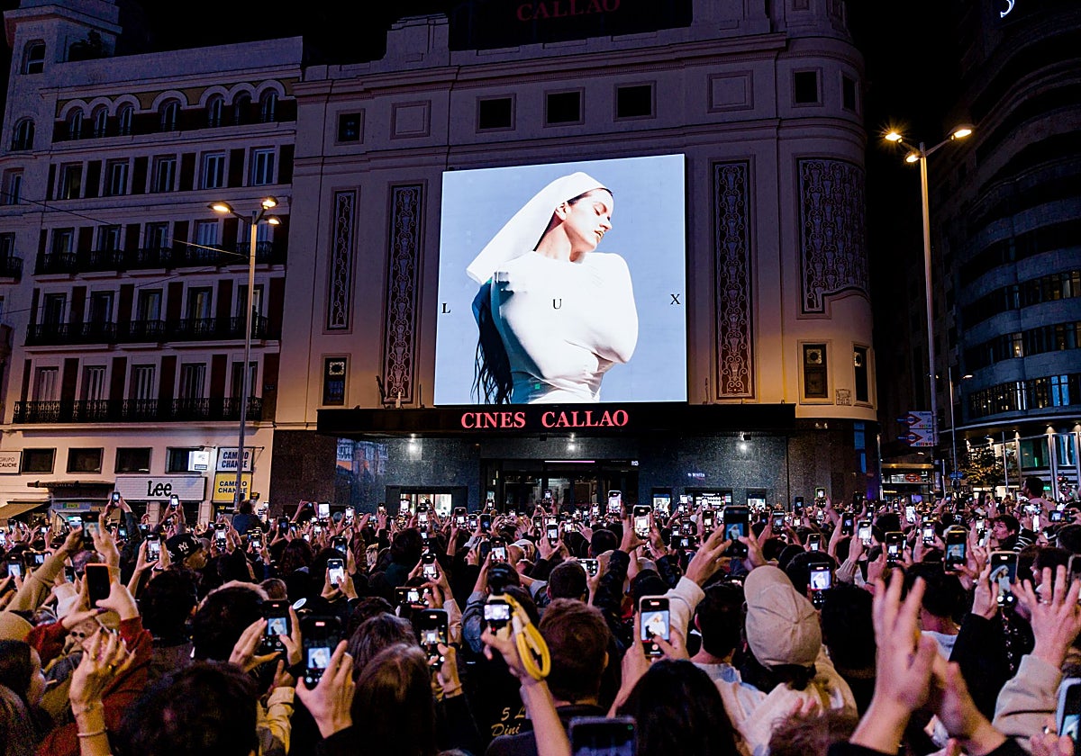 Decenas de personas observan la portada del nuevo álbum de Rosalía, 'Lux', en la plaza de Callao