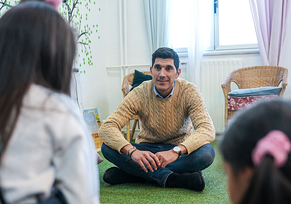 Diego Olivar, director del CEIP, conversa con dos alumnas en la biblioteca