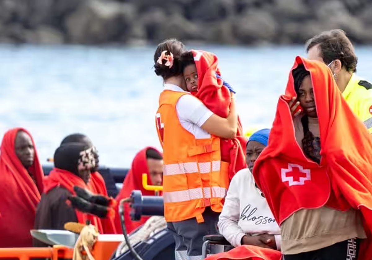 Agentes de los equipos de emergencia atienden a migrantes en el muelle de Arrecife