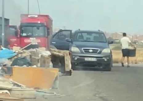 Imagen secundaria 1 - Karim recoge algo de ropa en un camino de tierra aledaño al polígono más cercano a Fabrik; en las fotos inferiores, un grupo de jóvenes arroja escombros de forma ilegal en Humanes, y paquetes de mascarillas N99 abandonados en otro 'vertedero'.
