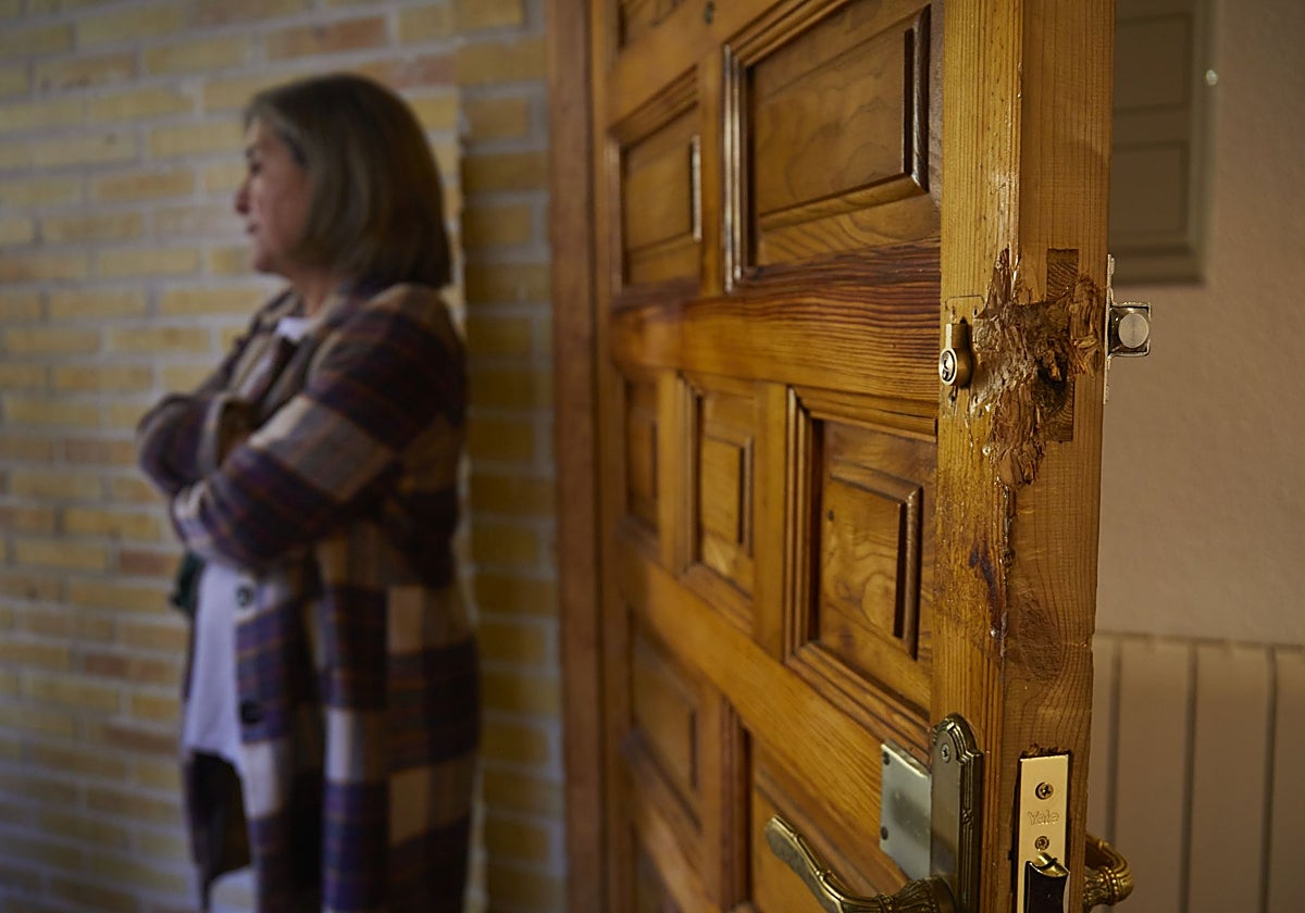 La dueña del chalé, Cristina Ramiro, junto a la puerta de madera forzada