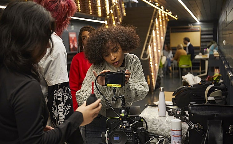 Imagen principal - Varios alumnos de la Escuela Dentro Cine trabajan en la producción de un cortometraje, en Cineteca, Matadero. Junto a ellos, el cineasta y codirector, Pedro Sara, y la delegada de Cultura, Turismo y Deporte, Marta Rivera de la Cruz