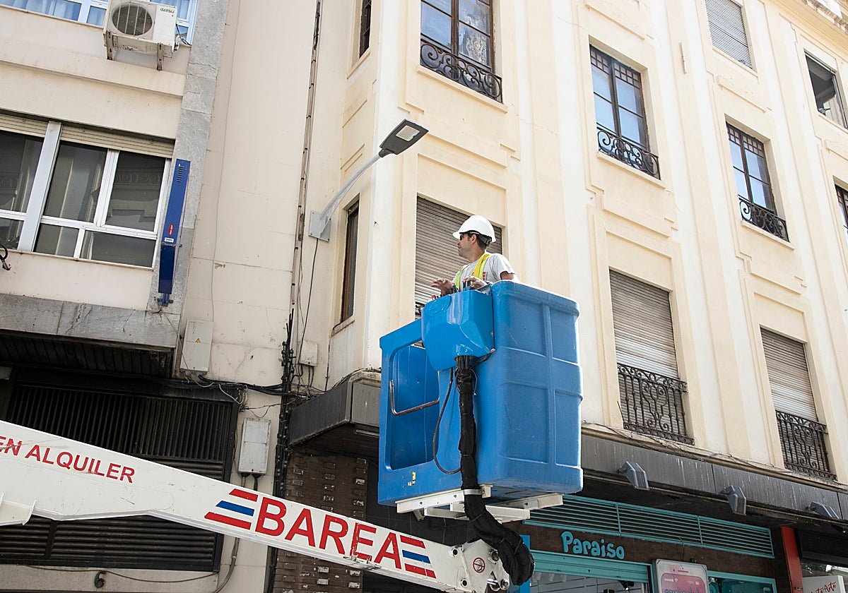 Un operario coloca una luminaria nueva en Cruz Conde