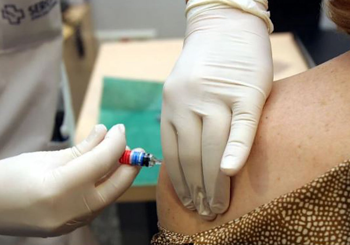 Un sanitario inyecta la vacuna de la gripe