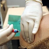 Un sanitario inyecta la vacuna de la gripe