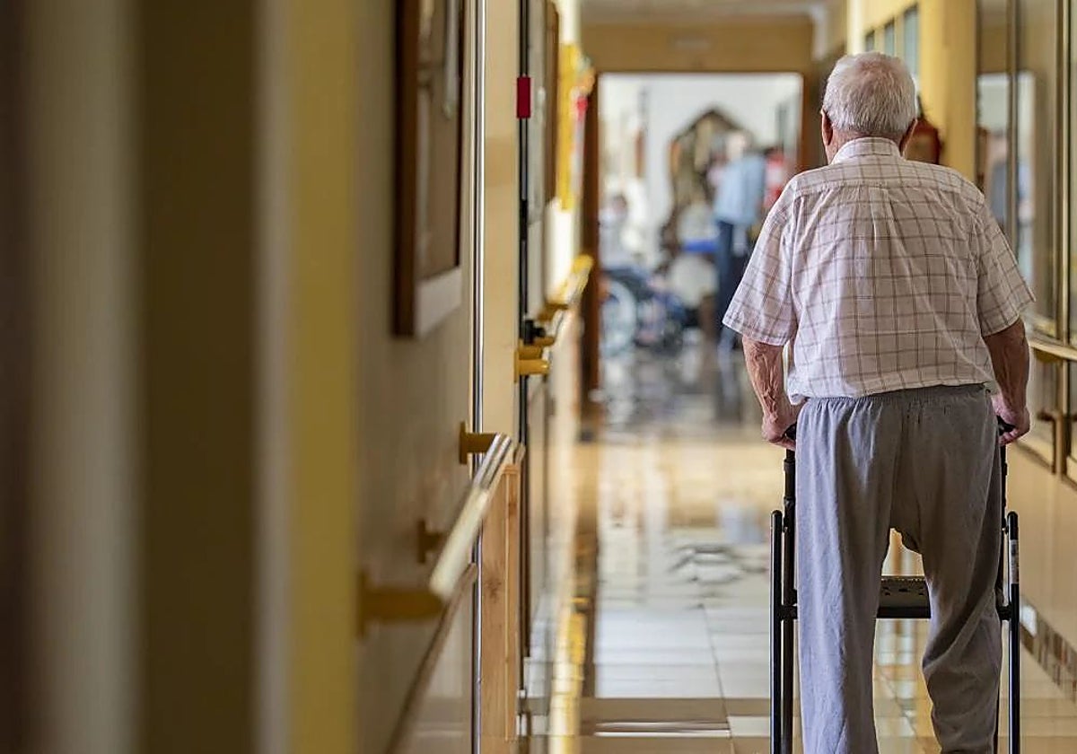 Un anciano pasea por el pasillo de una residencia