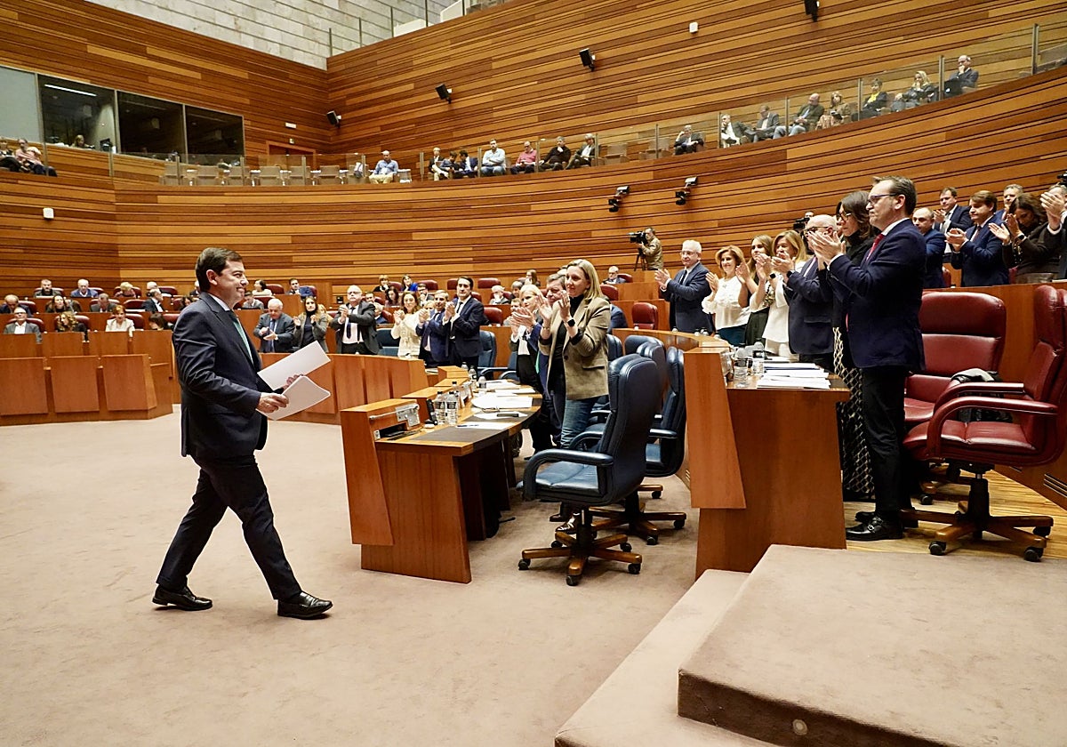El presidente de la Junta, Alfonso Fernández Mañueco, regresa a su escaño arropado por el aplauso de la bancada del PP y su Gobierno