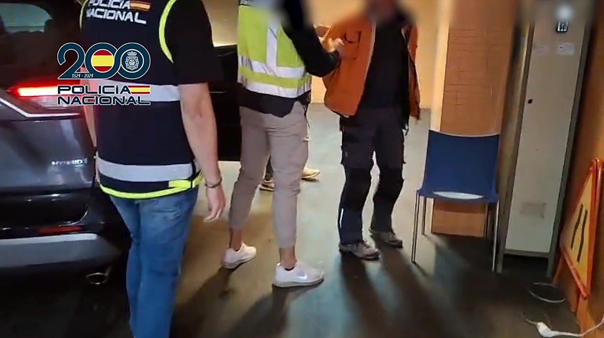 El fugitivo detenido, custodiado por agentes de la Policía Nacional de Alicante