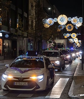 Secondary image 2 - Above these lines, a passerby greets the caravan crossing the Plaza Mayor in Valladolid. Below, participants in this initiative in Salamanca take a photo and taxis cross one of the illuminated streets of Valladolid