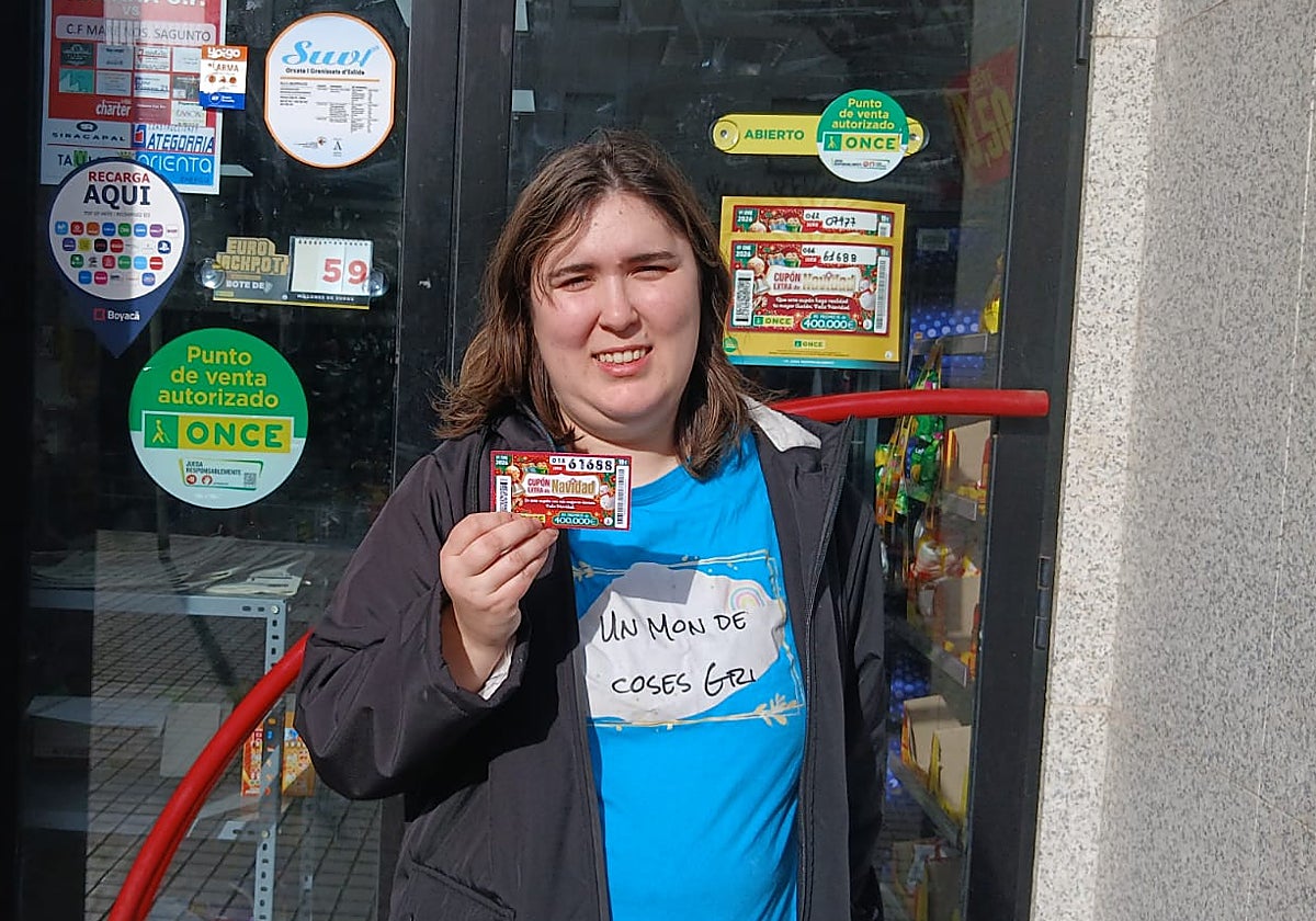 La vendedora de la ONCE Grisela Martínez muestra el número del segundo premio, con el que ha repartido 2,8 millones de euros en un municipio de Castellón
